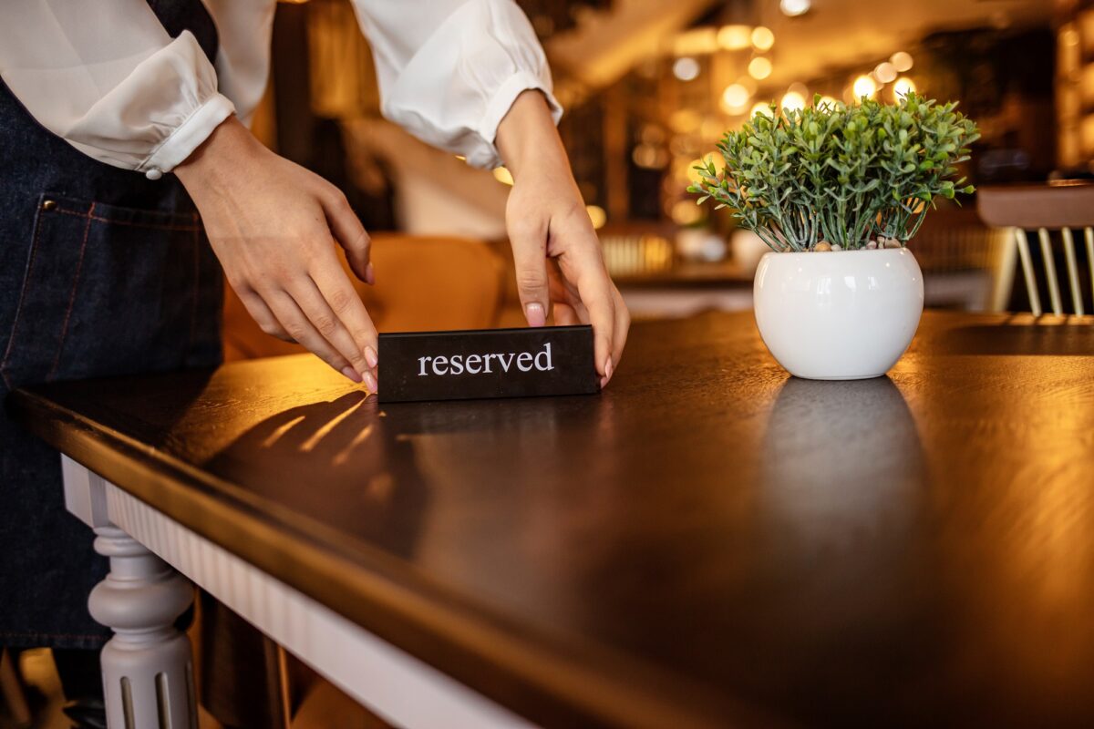 waitstaff putting reserved card onto restaurant table